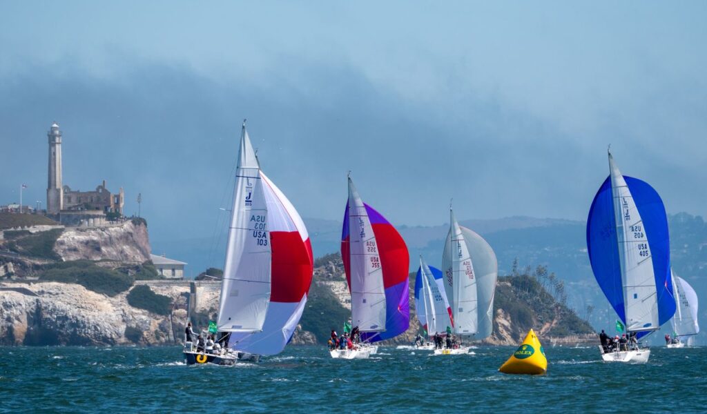 Vibrant sailboat race in San Francisco Bay with Alcatraz in the background.