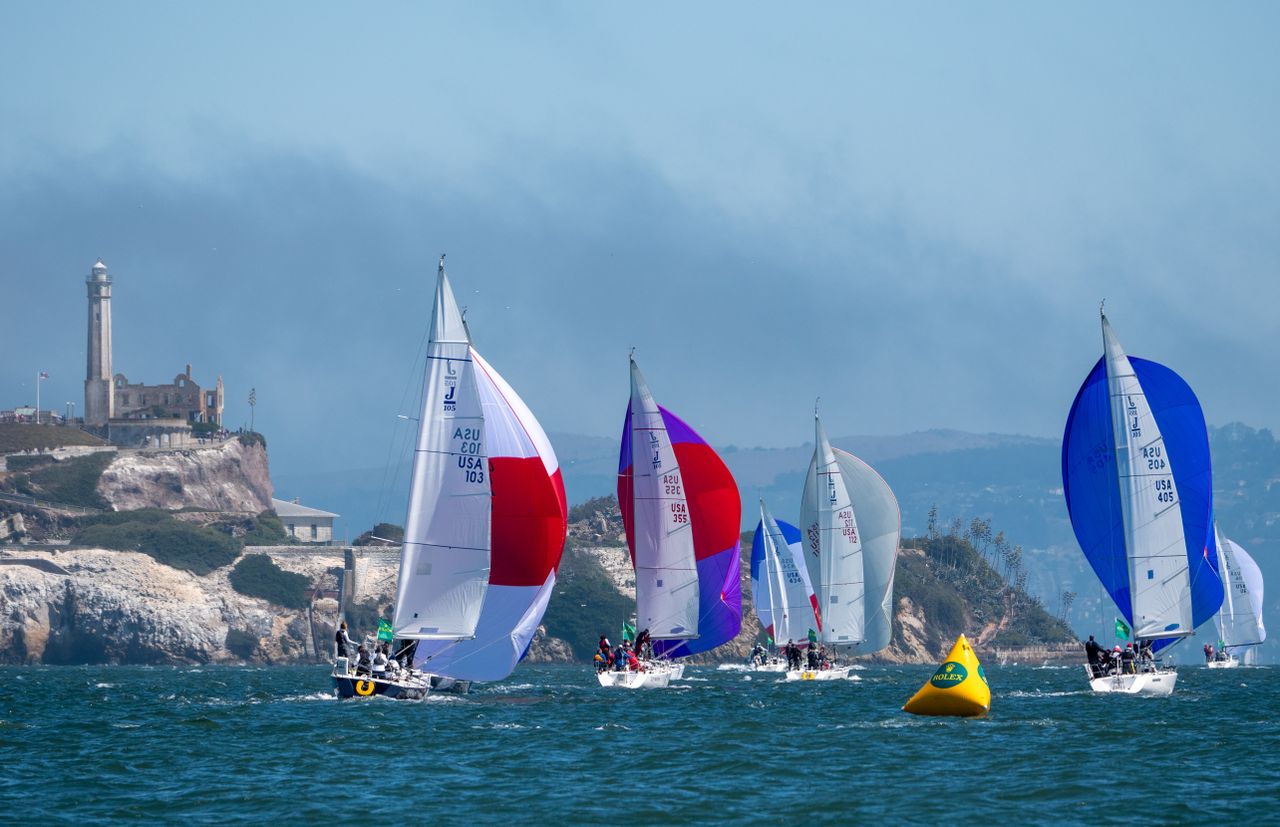 Vibrant sailboat race in San Francisco Bay with Alcatraz in the background.